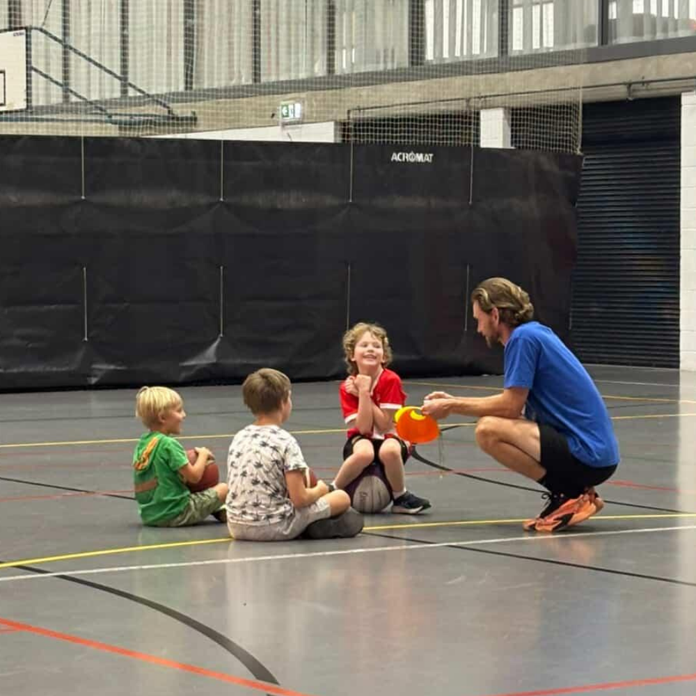 Coach James with young basketball players at NCIE Redfern