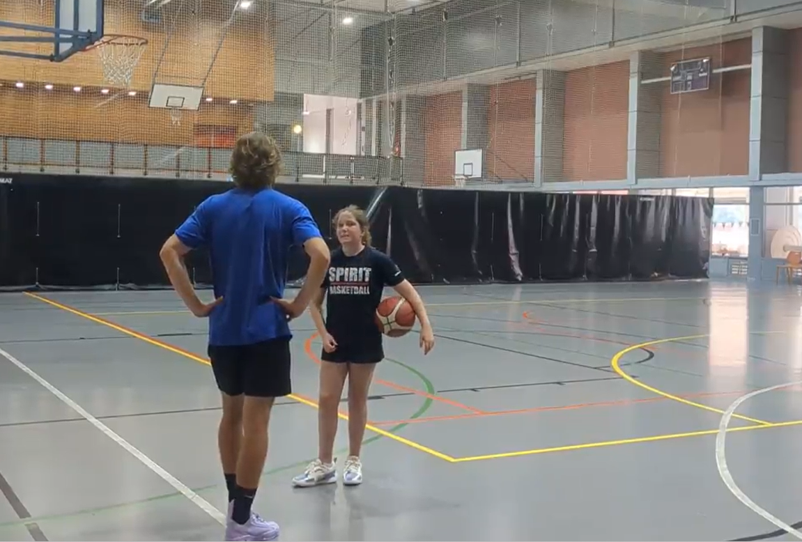 Coach James in a private coaching session with a young player on the basketball court